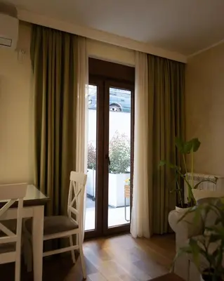 a living room with a table and a glass door at Apartman Korićanac II Vrnjačka Banja in Vrnjačka Banja