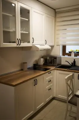 a kitchen with white cabinets and a counter top at Apartman Korićanac II Vrnjačka Banja in Vrnjačka Banja