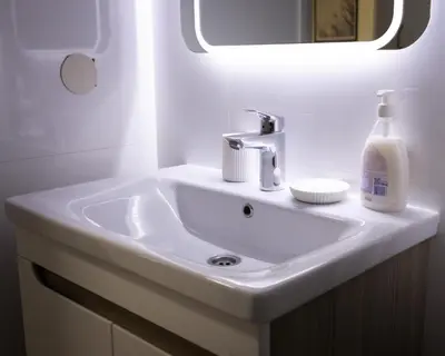 a white sink in a bathroom with a mirror at Apartman Korićanac II Vrnjačka Banja in Vrnjačka Banja