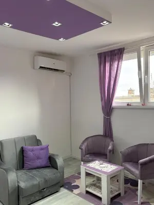 a living room with two chairs and a table at Apartman LILLY in Paraćin