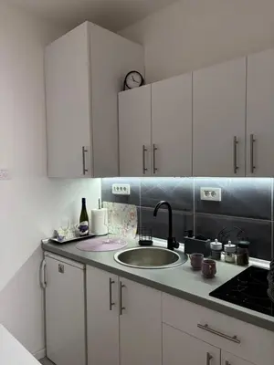a kitchen with white cabinets and a sink at Apartman LILLY in Paraćin