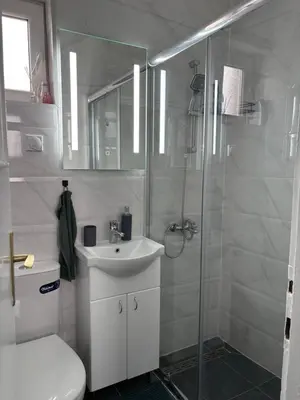 a bathroom with a toilet and a sink and a shower at Apartman LILLY in Paraćin