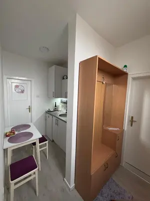 a small kitchen with a small table and a cabinet at Apartman LILLY in Paraćin