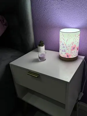 a table with a lamp and a purple wall at Apartman LILLY in Paraćin