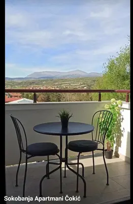 a table and chairs on a balcony with a view at Apartmani Čokić Sokobanja in Soko Banja