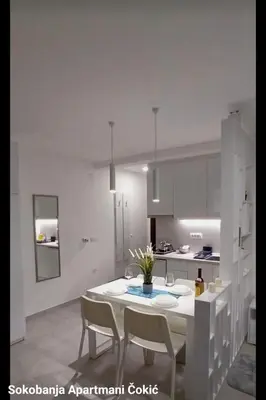 a white kitchen with a white table and chairs at Apartmani Čokić Sokobanja in Soko Banja