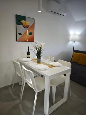 a white dining room table with white chairs and a painting at Apartmani Čokić Sokobanja in Soko Banja