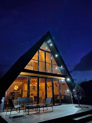 a house with a large glass facade at night at Kod Lutajuceg in Despotovac