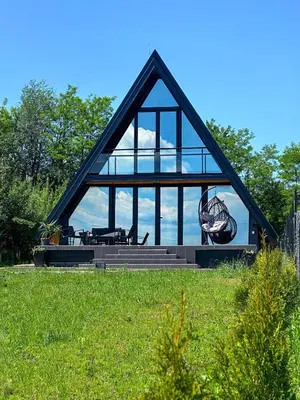 a house with a large window on top of a field at Kod Lutajuceg in Despotovac