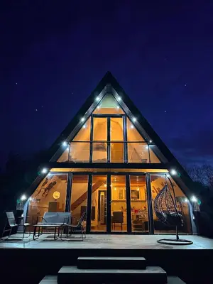 a large house with lights on it at night at Kod Lutajuceg in Despotovac