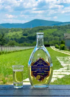 a bottle of wine and a glass on a table at Kod Lutajuceg in Despotovac