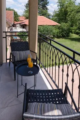 a patio with two benches and a table on a balcony at Vila Dara in Vrnjačka Banja