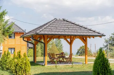 a wooden pavilion with a table and chairs in a yard at Brvnare Janković in Goč