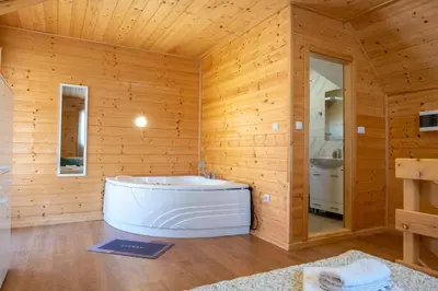 a bathroom with a white tub in a wooden wall at Brvnare Janković in Goč