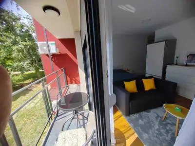 a small apartment with a balcony with a couch at OgiApartman in Vrnjačka Banja