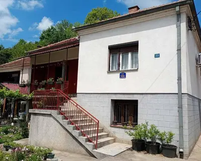a white building with a staircase in front of it at BoHan sobe Vladičin Han in Vladičin Han