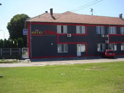 a red and black building with a sign on it at Garni hotel Alma in Pirot