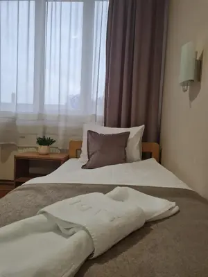 a white bed with a pillow and a window at Garni hotel Alma in Pirot