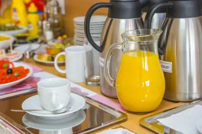 a glass jug of orange juice sitting on a kitchen counter at Garni hotel Alma in Pirot