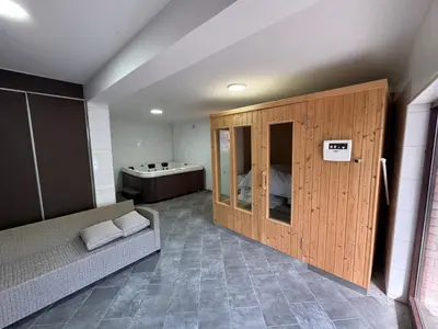 a room with a couch in a room with a tub at Lisine Ribnjak in Despotovac