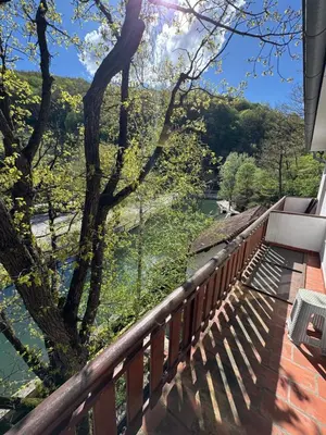 a balcony with a view of a river at Lisine Ribnjak in Despotovac