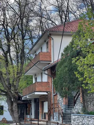 a brick house with a balcony on top of it at Lisine Ribnjak in Despotovac