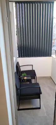 a balcony with two black chairs and a window at Mila in Soko Banja