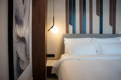 a bedroom with a bed and a wall with stripes at Hotel Rubin DHS in Kruševac