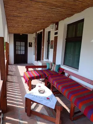 a porch with two wooden benches and a table at Vila Jagoda in Bojnik