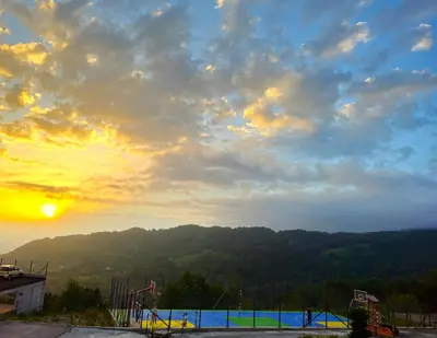 a view of a playground with the sunset in the background at Apartman The Nest in Kopaonik