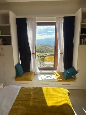 a bedroom with a large window with a view at Apartman The Nest in Kopaonik