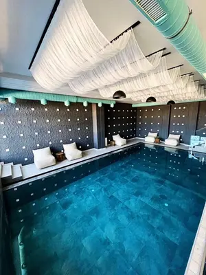 a large swimming pool with blue water in a building at Apartman The Nest in Kopaonik