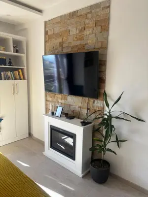 a living room with a fireplace and a flat screen tv at Apartman The Nest in Kopaonik