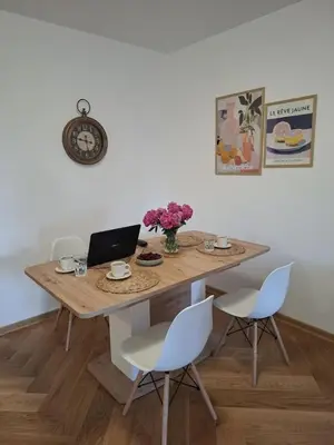 a dining room table with a laptop and chairs at Nikana in Vrnjačka Banja