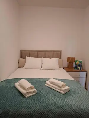 a bedroom with a bed with two towels on it at Nikana in Vrnjačka Banja