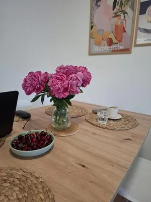 a table with a vase of flowers and a bowl of fruit at Nikana in Vrnjačka Banja