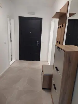 a hallway with a black door and a kitchen at Brand new apartment in the city center in Niš