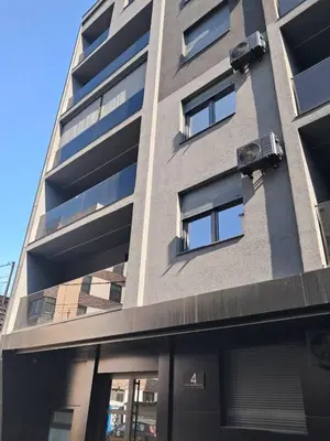 a tall building with windows on the side of it at Brand new apartment in the city center in Niš