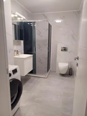 a white bathroom with a shower and a toilet at Brand new apartment in the city center in Niš
