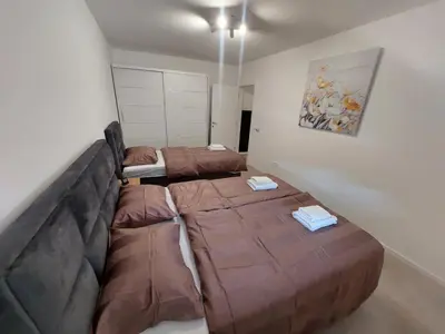 a living room with two beds and a couch at Brand new apartment in the city center in Niš