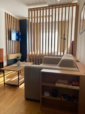 a bedroom with a bed and a desk and a table at NLux Nest Milmari in Kopaonik