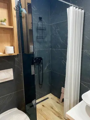 a shower with a glass door in a bathroom at NLux Nest Milmari in Kopaonik