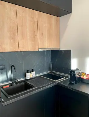 a kitchen with a sink and wooden cabinets at NLux Nest Milmari in Kopaonik