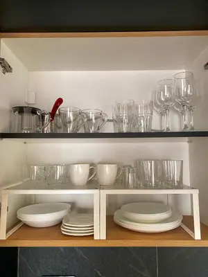 a shelf with plates and bowls and glasses on it at NLux Nest Milmari in Kopaonik