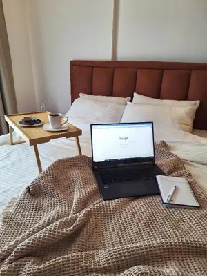 a laptop computer sitting on a bed with a table at NLux Nest Milmari in Kopaonik