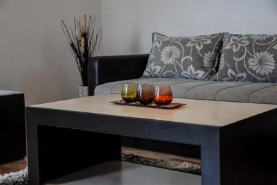 a coffee table with three glasses on it in front of a couch at River lux in Bukorovac