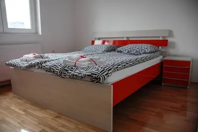 a bedroom with a bed with a red headboard at River lux in Bukorovac