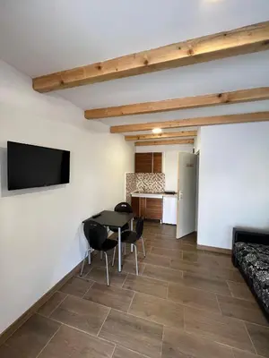 a living room with a table and chairs and a kitchen at Studio in Soko Banja