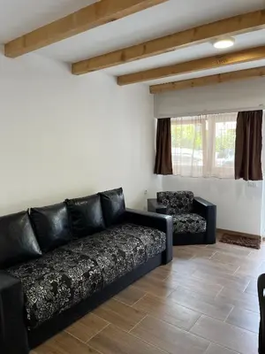a living room with a black couch and two chairs at Studio in Soko Banja