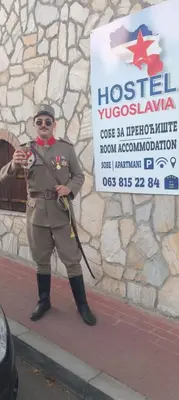 a man in uniform standing in front of a sign at Yugoslavija Lux 3 in Aleksandrovac